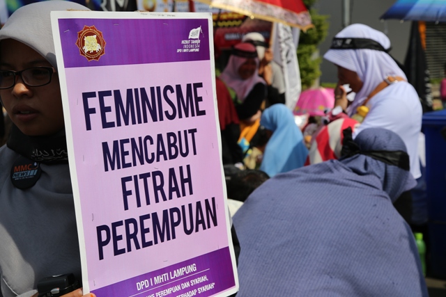 Salah seorang peserta aksi MHTI membawa kertas bertuliskan "Feminisme Mencabut Fitrah Perempuan". Photo By : Syahidah/MINA