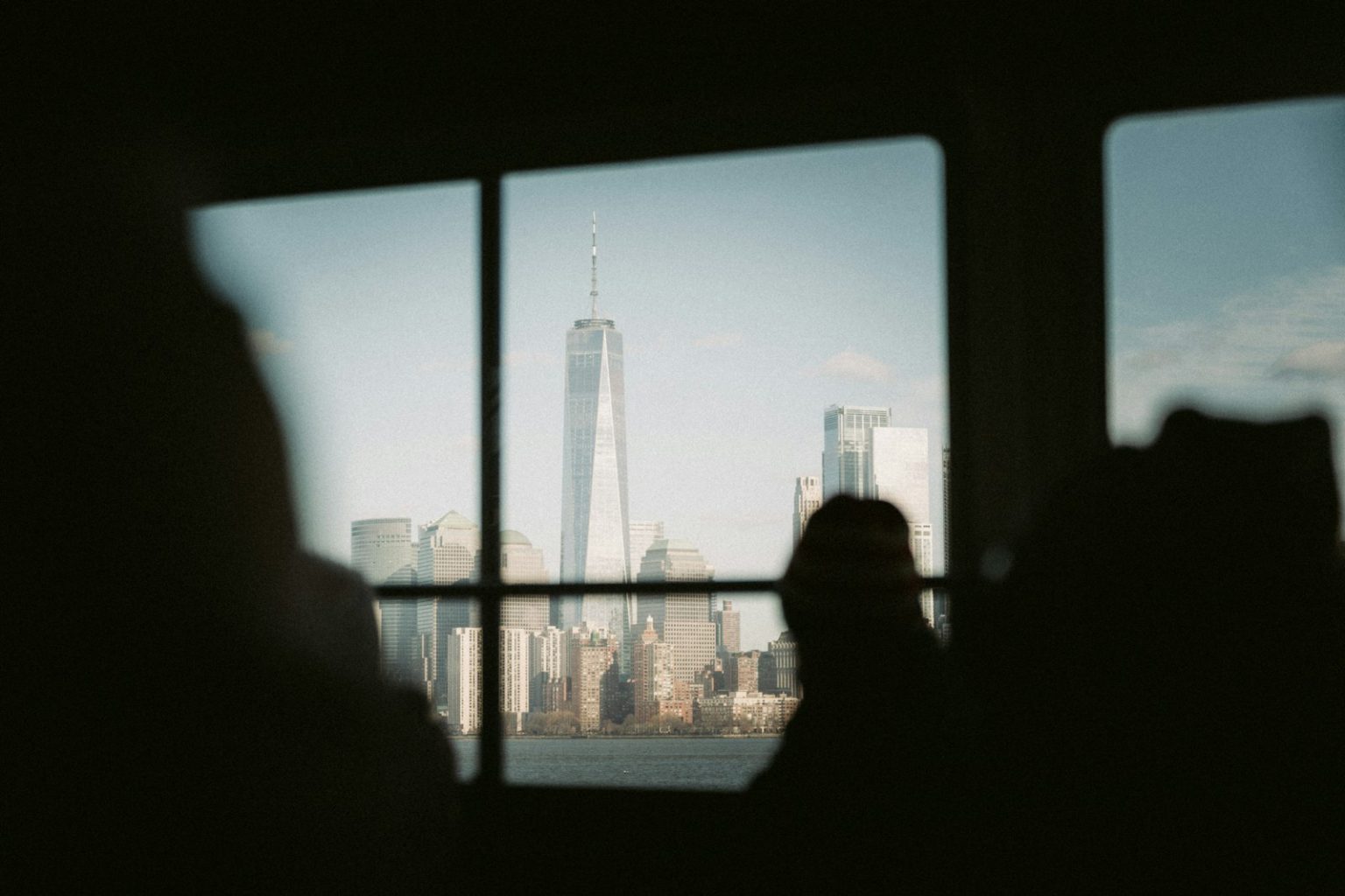 A person looking out a window at a city