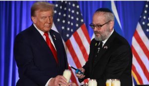 Presiden Donald Trump dan Rabbi Yehuda Kaploun menyalakan lilin selama acara peringatan pada 7 Oktober di Trump National Doral Golf Club di Doral, Florida. (Joe Raedle/Getty Images)